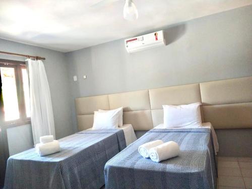 a room with two beds with towels on them at Residencial Mont Sinai Tonziro -Taperapuan in Porto Seguro
