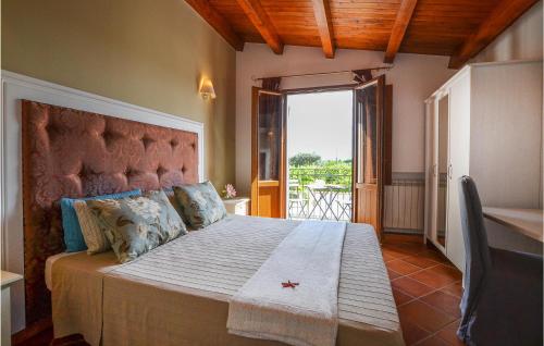 ein Schlafzimmer mit einem großen Bett und einem großen Fenster in der Unterkunft Villa Musasealdoge in Partinico