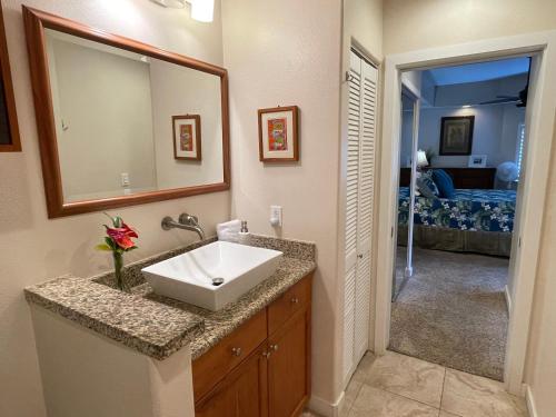 a bathroom with a sink and a mirror at Beach Villas at Kahalu'u in Kailua-Kona