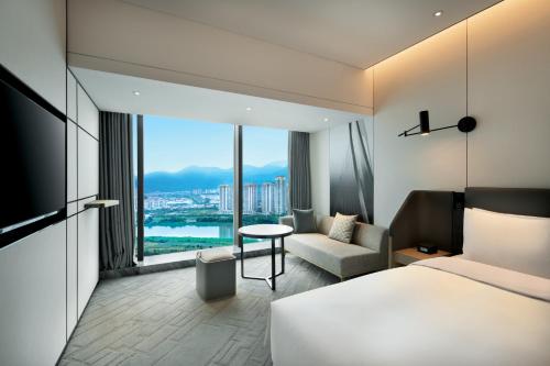 a hotel room with a bed and a chair and a window at Crowne Plaza Quanzhou Riverview by IHG in Quanzhou