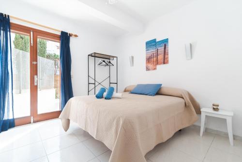 ein Schlafzimmer mit einem Bett mit blauen Kissen darauf in der Unterkunft Apartments Residencial Cala Ferrera in Cala Ferrera