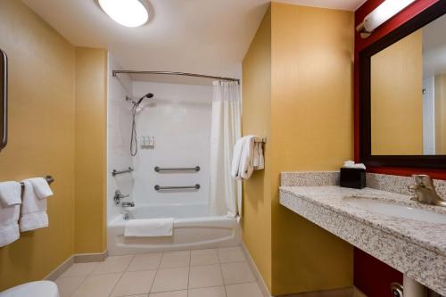 y baño con ducha y lavamanos. en Sonesta Select Detroit Novi, en Novi