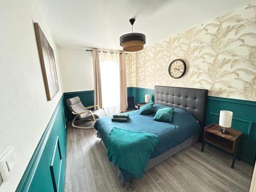 a bedroom with a bed and a clock on the wall at SPACIEUX DUPLEX PRES DES QUAIS DE SEINE LINGE MAISON FOURNI PARKING GRATUIT 4 CHAMBRES bienvenue à vous in Rouen