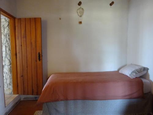 a bedroom with a bed and a wooden door at New Village in Vila Nova da Baronia