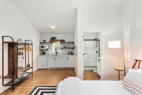 a white living room with a white couch and a kitchen at Studio Unit.hōʻoluʻolu in Chandler