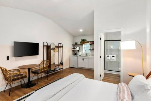 a bedroom with a bed and a table and a kitchen at Studio Unit.hōʻoluʻolu in Chandler