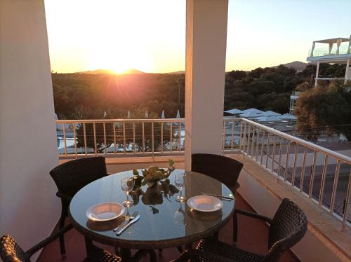 una mesa y sillas en un balcón con vistas a la puesta de sol en Apartments Residencial Cala Ferrera, en Cala Ferrera