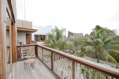 a balcony of a house with a chair and palm trees at Kai Tulum in Tulum