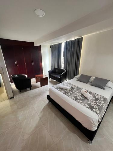 um quarto com uma cama e uma cadeira num quarto em Hotel Boutique Santa Ana em Cartago