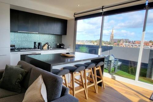 a kitchen with a large kitchen island with bar stools at Penthouse 3 bedroom 6 guests 2 bathrooms in Melbourne