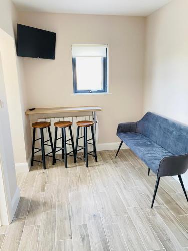 a living room with a table and stools at Portmagee Village Apartments in Portmagee