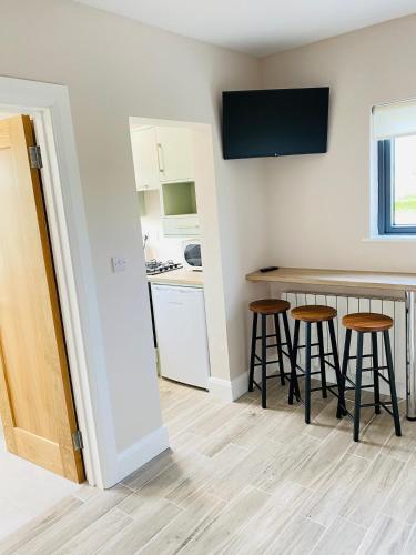 a kitchen with a counter and stools in a room at Portmagee Village Apartments in Portmagee