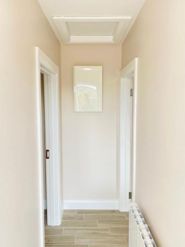 a hallway with white walls and a white door at Portmagee Village Apartments in Portmagee