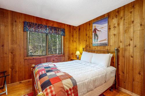 Un dormitorio con paredes de madera y una cama en una habitación. en 278 Ghia Farm Road, en Ludlow