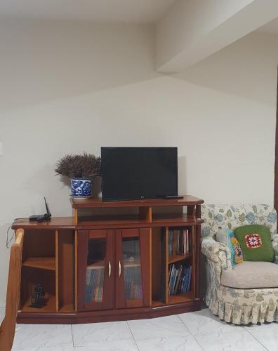 a wooden entertainment center with a flat screen tv on top at Pousada Morada dos Pássaros in Pedro Leopoldo