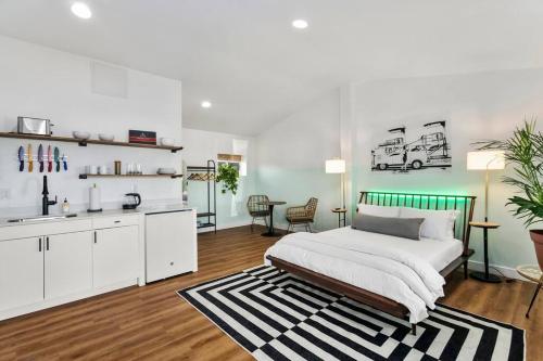 a white bedroom with a bed and a kitchen at Mokuoeo Studio suite.nui in Chandler