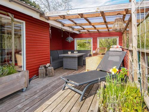 a wooden deck with a picnic table and a pergola at 6 person holiday home in R nde in Rønde