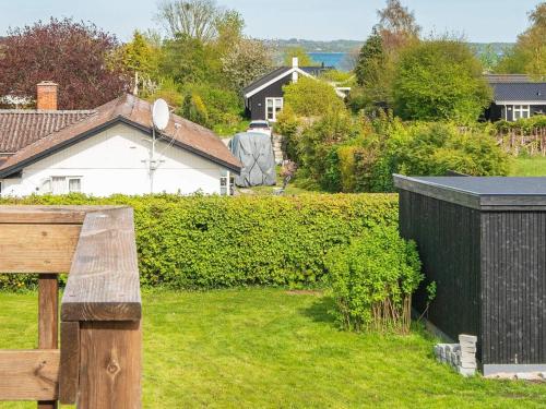 un jardín con un banco de madera en un patio en 6 person holiday home in Hornslet en Hornslet