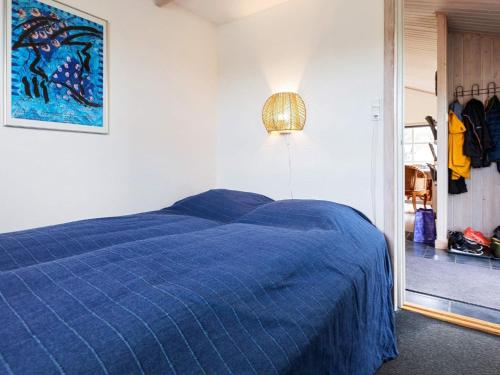een bed met een blauw dekbed in een slaapkamer bij Two-Bedroom Holiday home in Løkken 20 in Løkken