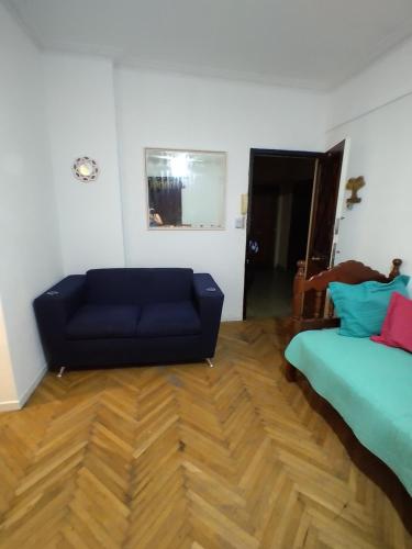 sala de estar con sofá azul y cama en Dpto. 3 Ambientes en Mar del Plata
