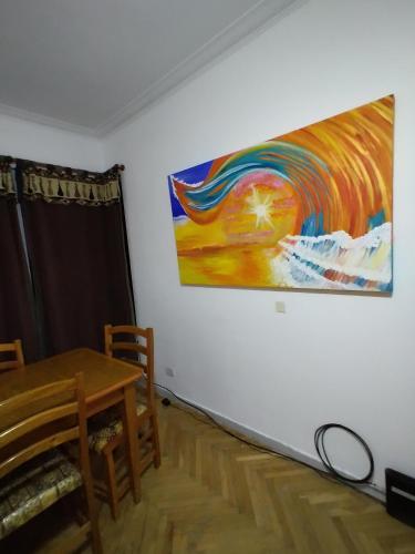 un comedor con una mesa y una pintura en la pared en Dpto. 3 Ambientes en Mar del Plata