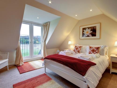 a bedroom with a bed and a large window at Kestrel Cottage - 27937 in Cambusbarron