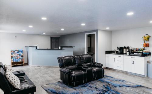 a living room with a leather chair and a kitchen at Econo Inn in Worland