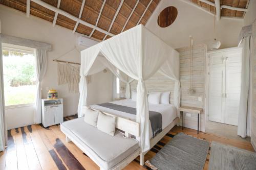 a bedroom with a white canopy bed and a rug at Kai Tulum in Tulum