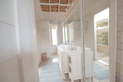 a white bathroom with two sinks and a mirror at Kai Tulum in Tulum