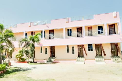 an exterior view of a building with palm trees at OYO 68320 Bgr Residency in Tirupati