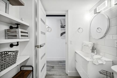 a white bathroom with a sink and a mirror at The Summit 702 in Panama City Beach