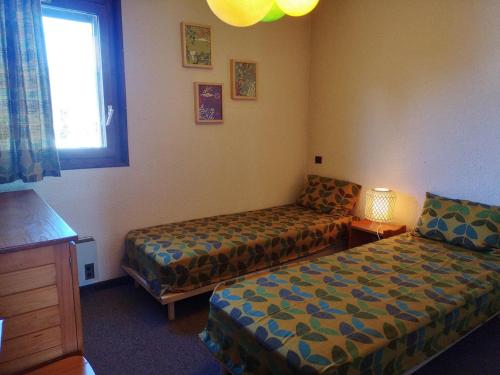 une chambre d'hôtel avec deux lits et une fenêtre dans l'établissement 2 pièces avec piscine et parking à Notre-Dame-de-Bellecombe, 4 pers - FR-1-595-16, à Notre-Dame-de-Bellecombe