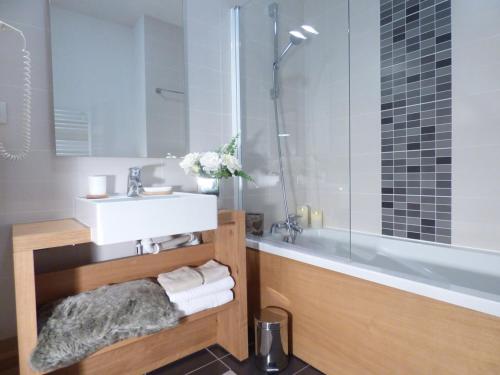 une salle de bain avec un lavabo et une baignoire dans l'établissement Appart 3 pièces aux Saisies - Piscine, Jacuzzi, Fitness - FR-1-594-102, à Hauteluce