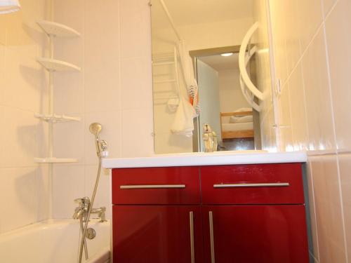 une armoire rouge dans une salle de bain avec un miroir dans l'établissement Studio cosy avec alcôve, proche centre des Saisies, balcon sud, 4 pers., classé 2*. - FR-1-594-147, à Hauteluce