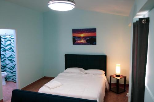 a bedroom with a white bed and a lamp at MAVS COMBATE BEACH CLUB in Cabo Rojo