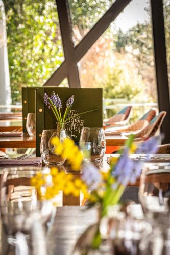 a table with glasses and flowers on top of it at The Weeping Willow in Bury Saint Edmunds