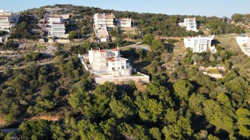 an aerial view of an estate on a hill with trees at Blue and White in Schinias