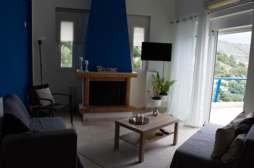 a living room with a fireplace and a blue wall at Blue and White in Schinias