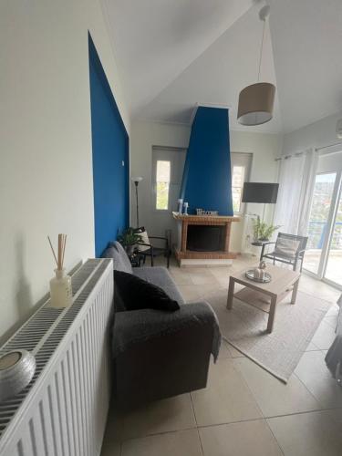 a living room with a couch and a blue wall at Blue and White in Schinias