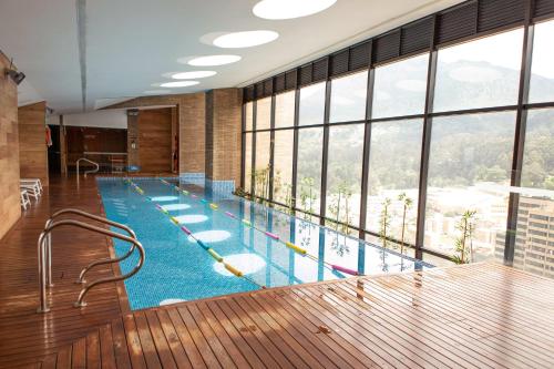 a large swimming pool with a large window at The Equilibrium Collection in Centro Internacional in Bogotá