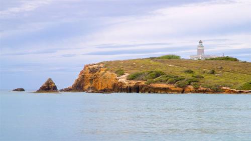a lighthouse on top of a hill with the water at MAVS COMBATE BEACH CLUB in Cabo Rojo