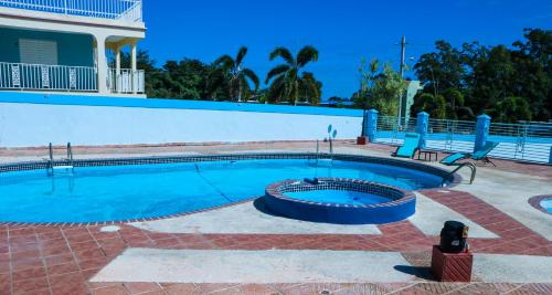 a swimming pool with a bench next to a house at MAVS COMBATE BEACH CLUB in Cabo Rojo