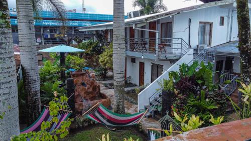 a courtyard with two hammocks and a building at Arenal Poshpacker in Fortuna
