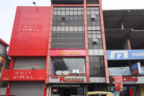 een hoog gebouw met rode en witte borden erop bij Hotel Kohinoor in Durgapur