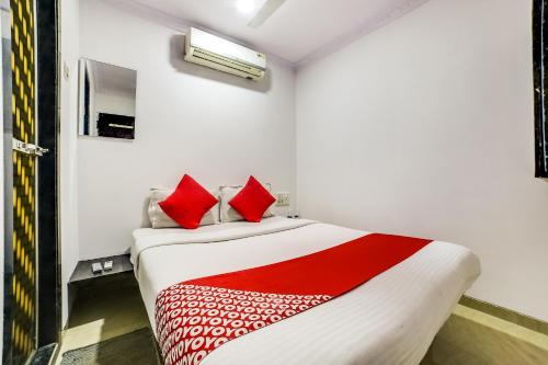 a bedroom with a large bed with red pillows at OYO 66982 Hotel Skyway Inn in Mumbai