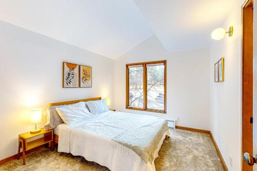 a white bedroom with a bed and a window at Adventures in Mount Bachelor #241 in Bend