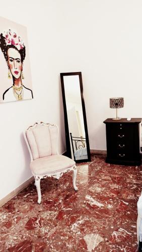 a room with a chair and a mirror at LA BARONESSA apartment- vicinissimo al policlinico in Messina