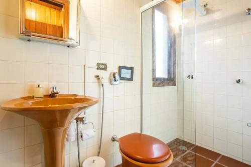 y baño con lavabo, aseo y ducha. en Suites no Alto do Capivari, en Campos do Jordão