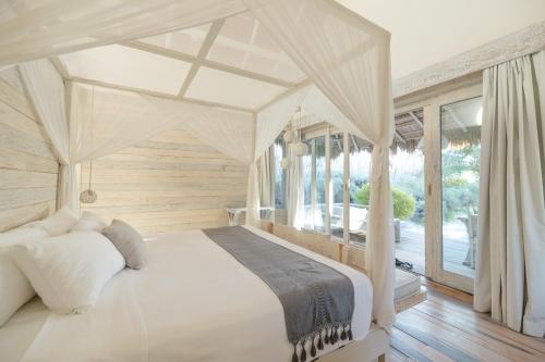 a bedroom with a white bed with a canopy at Kai Tulum in Tulum