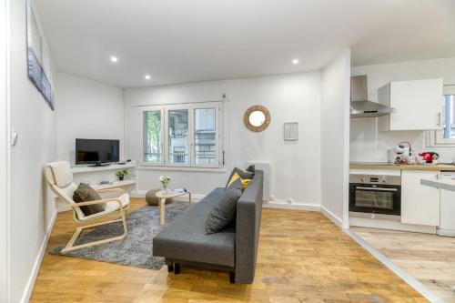 Il comprend un salon avec un canapé gris et une cuisine. dans l'établissement Le Prestige•Gare•Cours Jean Jaurès•Confort•Netflix, à Grenoble